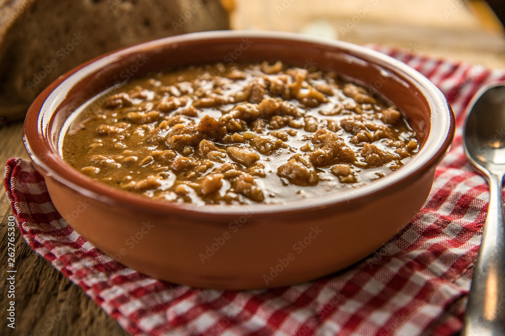 tripe stew sauce in brown ceramic pot on a wood table tripe stew sauce in brown ceramic pot on a wood table