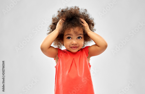 Obraz na płótnie childhood and people concept - overwhelmed little african american girl holding