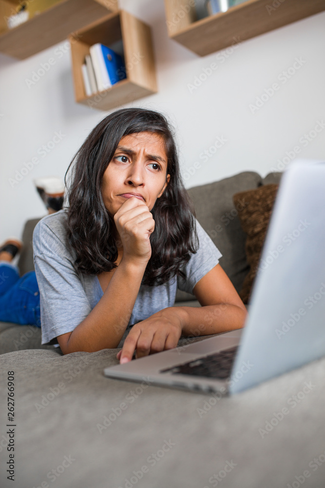 Young indian woman thinking in front of computer at home Young indian woman thinking in front of computer at home