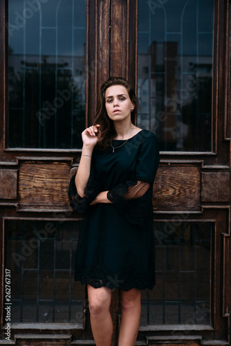 Young girl in green dress near old big building door photo