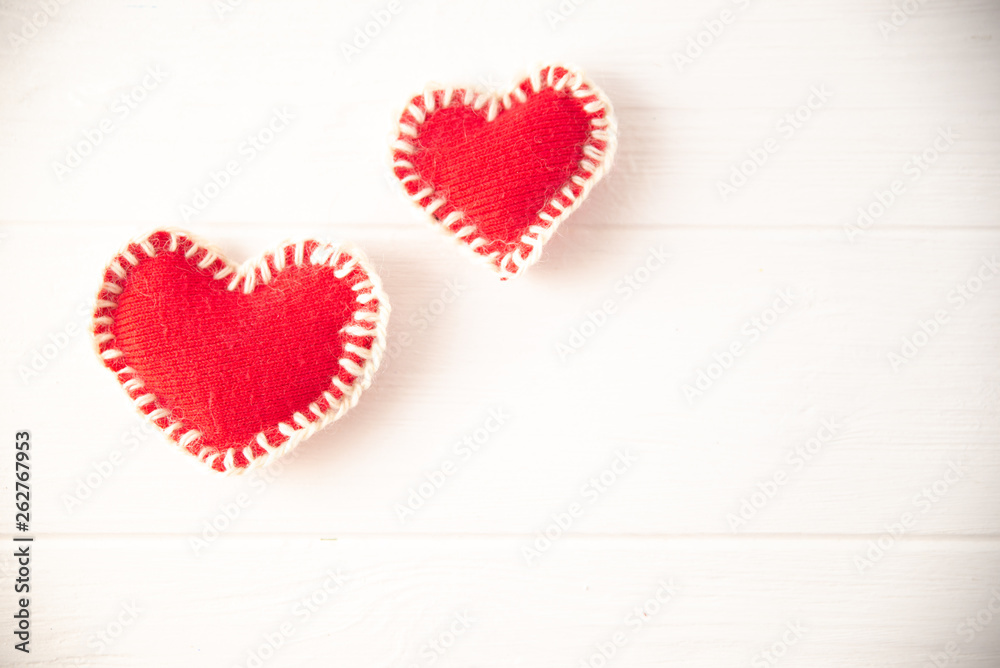 Red knitted soft fabric hearts on white background