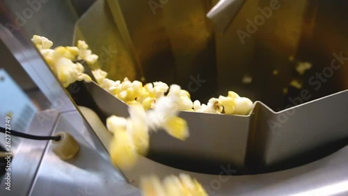 Process of cooking popcorn on the factory. Corn covered with salt 