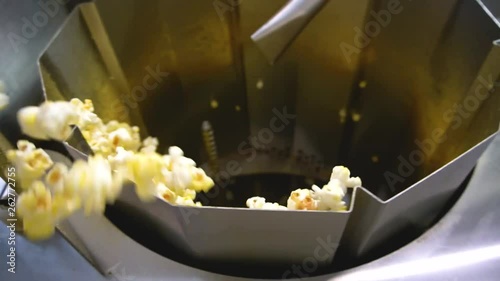 Process of cooking popcorn on the factory. Corn covered with salt 