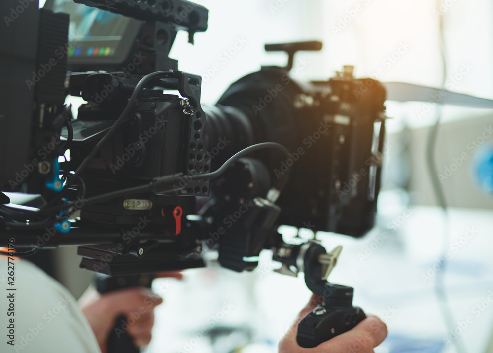 Video camera operator working with his equipment indoors Video camera operator working with his equipment indoors