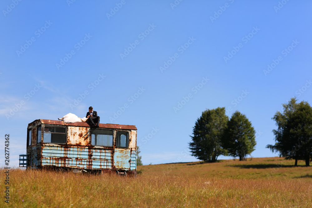 Beautiful wedding couple posing on old vagon
