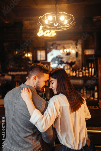Man and woman relax, couple hugs in bar