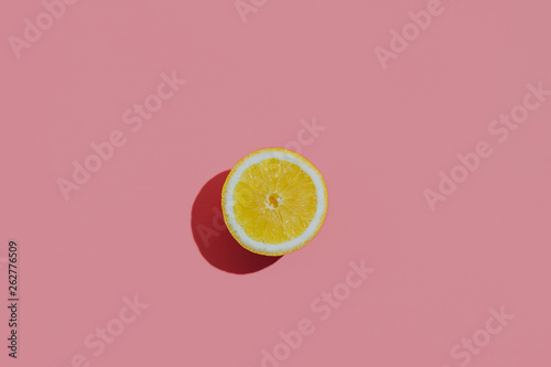 Fresh cutted lemon on a pastel pink background closeup at the left side of the table