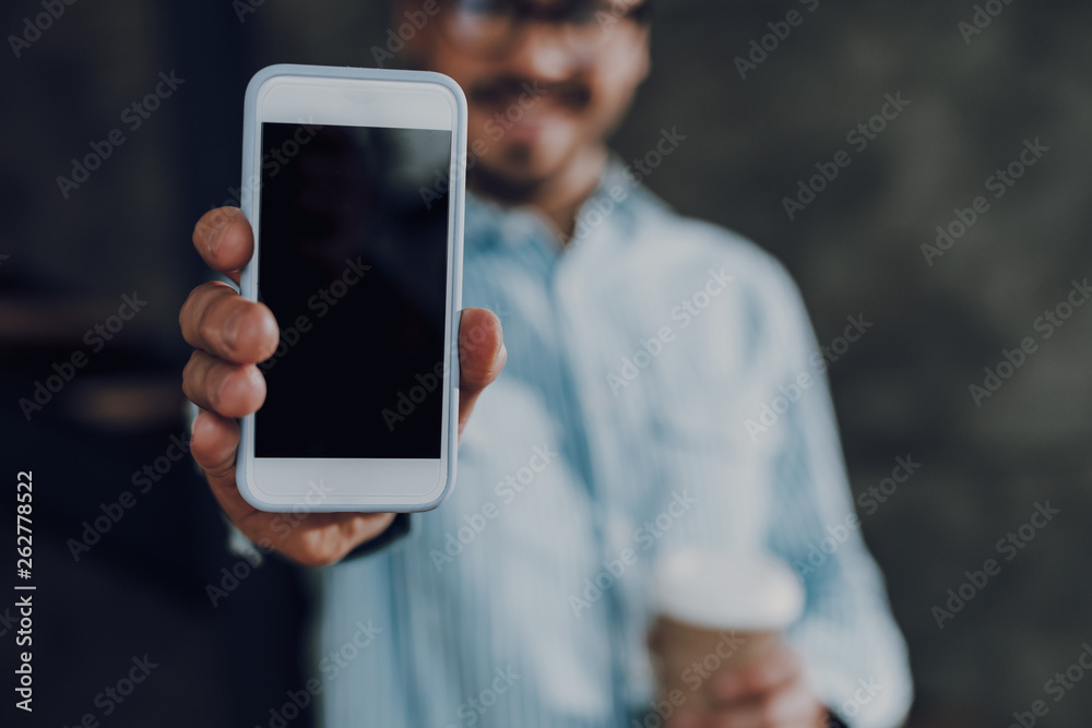 Young man with drink is showing smartphone screen Young man with drink is showing smartphone screen