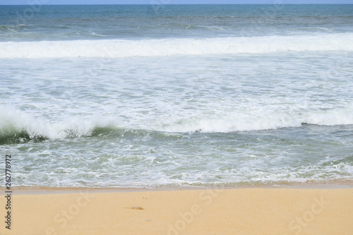 waves on the beach with beautiful white sand and blue sky background