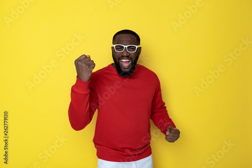 Half length of happy African man with funny eyeglasses posing in studio