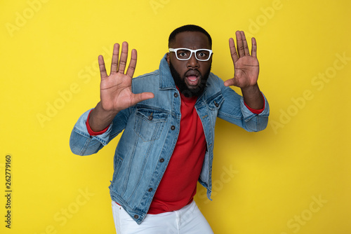 Half length of scared African man with opened mouth posing in studio