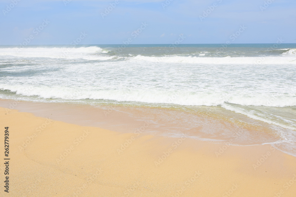 waves on the beach with beautiful white sand and blue sky background