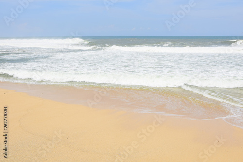 waves on the beach with beautiful white sand and blue sky background