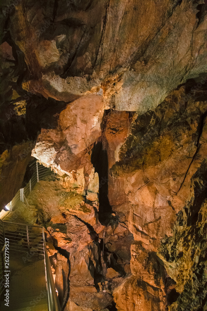 Obraz premium A footbridge allows you to visit the beautiful rock formations of the Antro del Monte Corchia cave in the Apuan Alps in Italy.