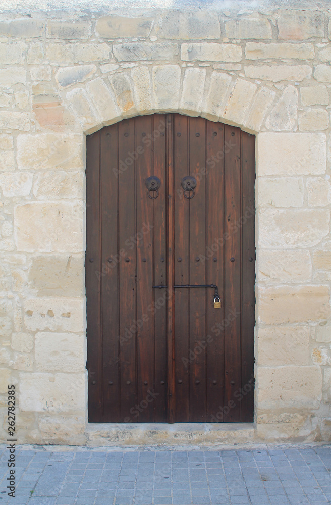 Old-fashioned wooden front door in stone wall