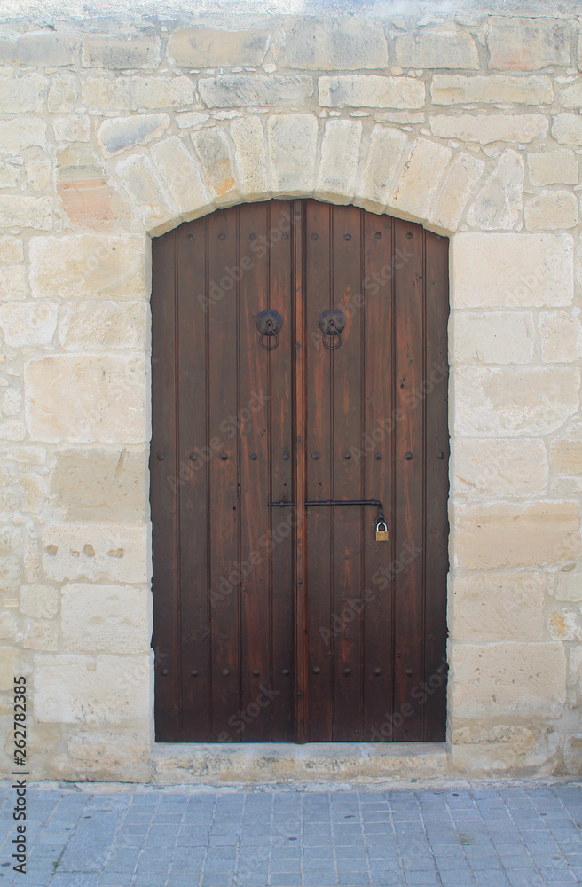 Old-fashioned wooden front door in stone wall Old-fashioned wooden front door in stone wall