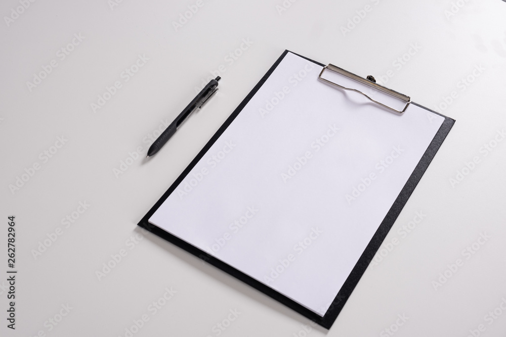 Tablet with writing paper with pen on white table Tablet with writing paper with pen on white table