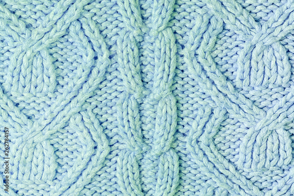 Knitted texture with patterns close-up. Blank blue background for layouts. Light photo. Knitted texture with patterns close-up. Blank blue background for layouts. Light photo.