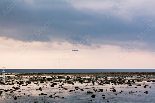 Plane flies through  Nature Nai Yang Beach Beach in Phuket from Thailand