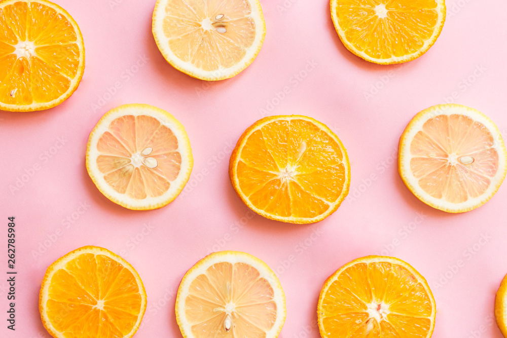 Pink background with chunks of lemon and oranges