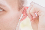 A man in headphones touches his ear