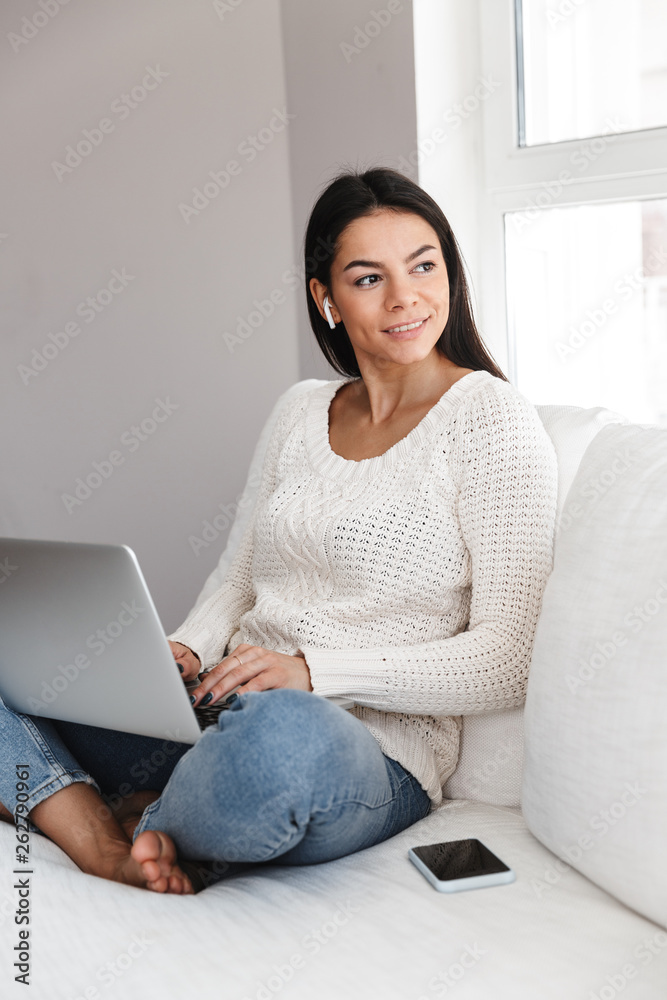 Pretty young woman relaxing on a couch at home Pretty young woman relaxing on a couch at home