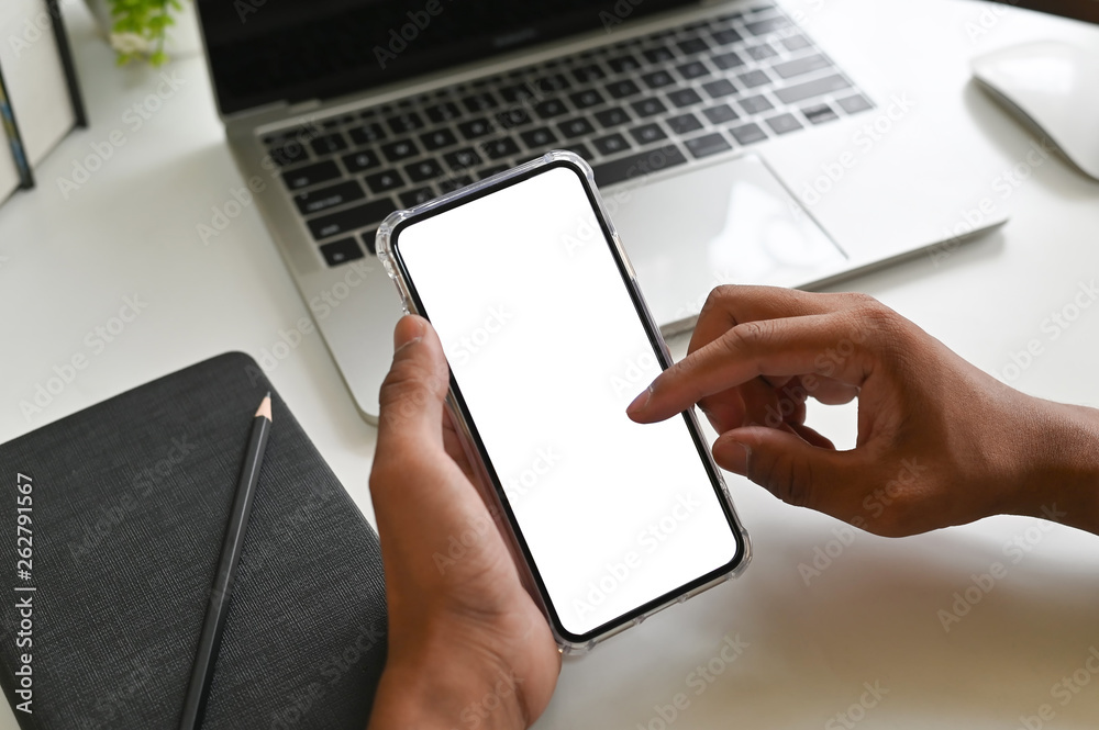 Closeup hands using mockup smartphone on office desk with clipping path. Closeup hands using mockup smartphone on office desk with clipping path.