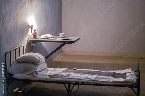 Принти на полотні Photo of the interior of the prison. bed and desk with lamp