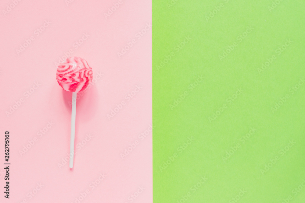 Sweet tasty pink lollipop on green and pink background. Minimal flat lay with copy space Sweet tasty pink lollipop on green and pink background. Minimal flat lay with copy space