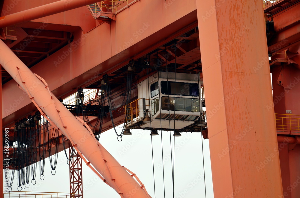 Gantry crane in the port, ready to discharge containers from the cargo ship. Gantry crane in the port, ready to discharge containers from the cargo ship.
