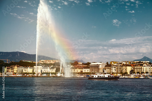 Beautiful sunset of the water jet fountain with rainbow in the lake of Geneva and the cityscape of Geneva, Switzerland