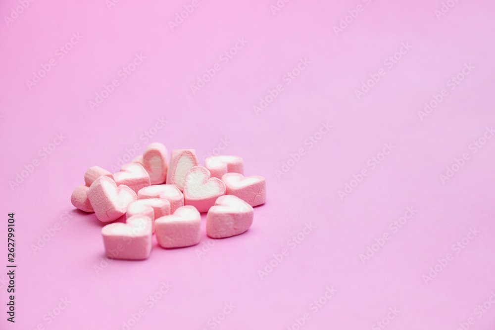 Sweet pink marshmallows on pink background with copy space
