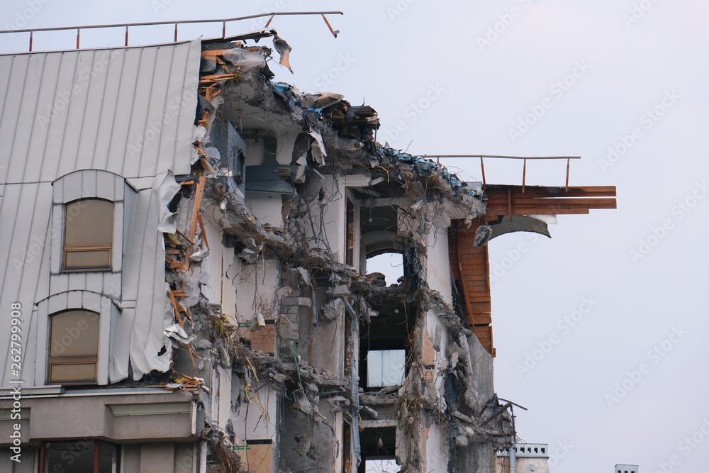 Demolished destructed building ruins. Demolition site in european city. Ruined house on a gray sky on cloudy day Demolished destructed building ruins. Demolition site in european city. Ruined house on a gray sky on cloudy day