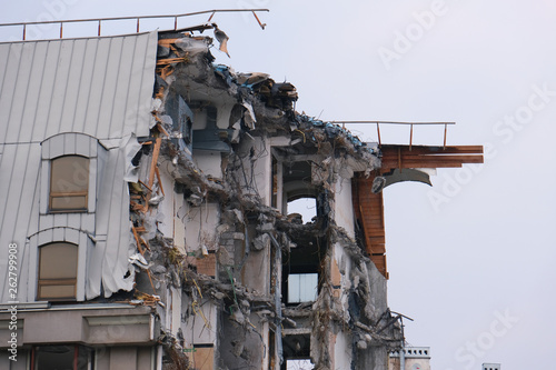 Demolished destructed building ruins. Demolition site in european city. Ruined house on a gray sky on cloudy day © Arseny