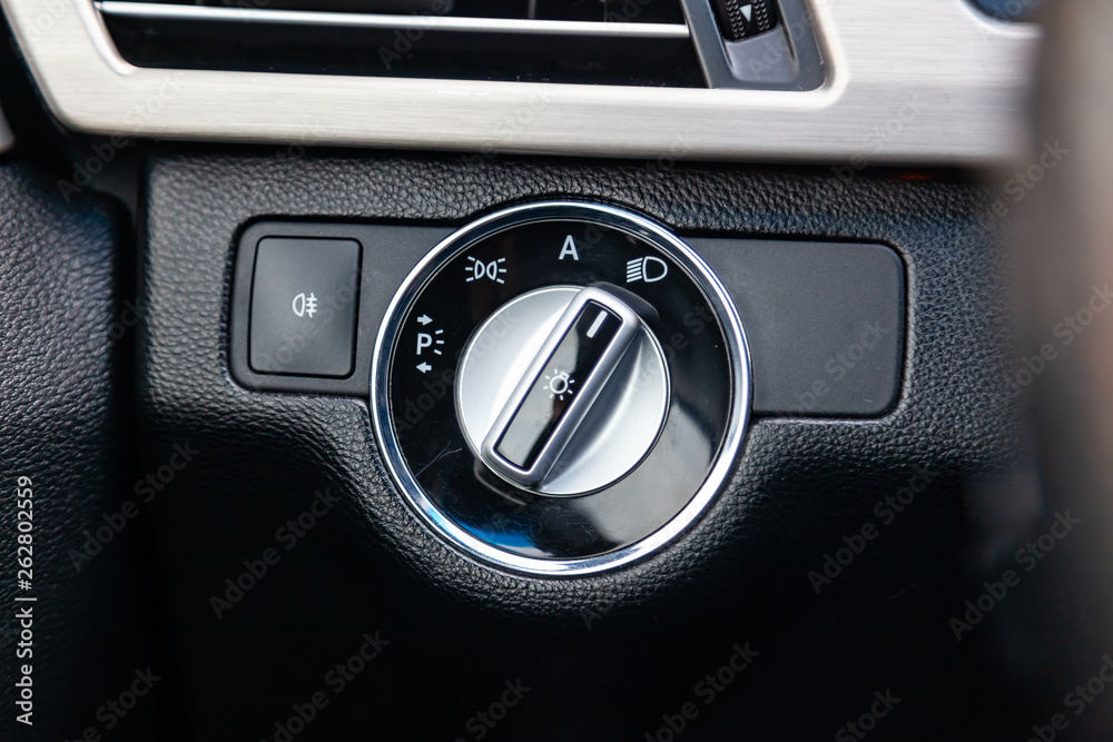 The interior of the car with a view of the dashboard lights switch buttons with light gray trim