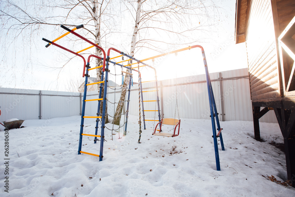 children's swing in the backyard in winter children's swing in the backyard in winter