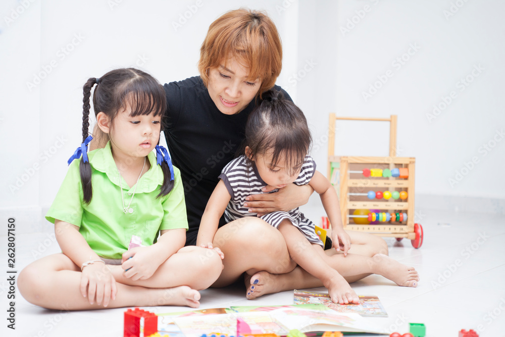 Mom is reading comic book with her daughters