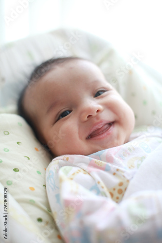 Baby girl is smiling and laugh on her cradle