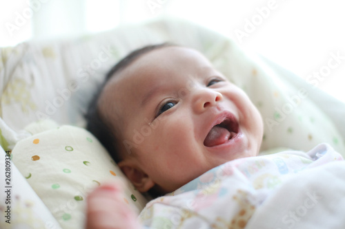 Baby girl is smiling and laugh on her cradle