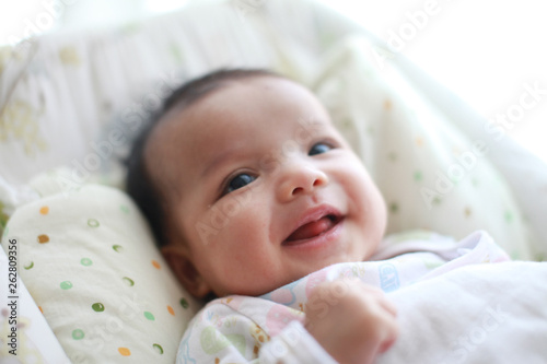 Baby girl is smiling and laugh on her cradle