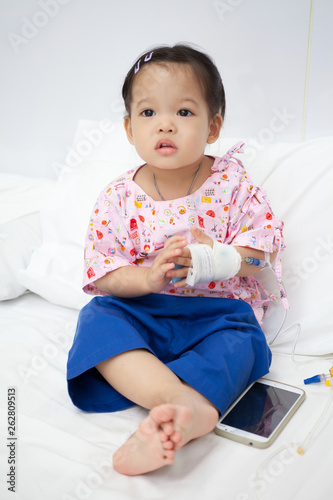 Baby have diarrhea and sitting on a bed in hospital with saline intravenous (iv)