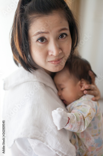 Mom is holding and kissing her baby with love