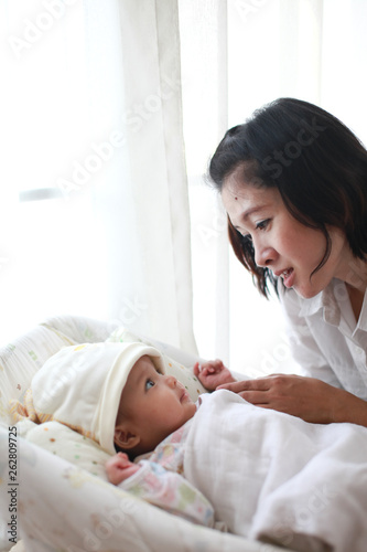 Mom is holding and kissing her baby with love