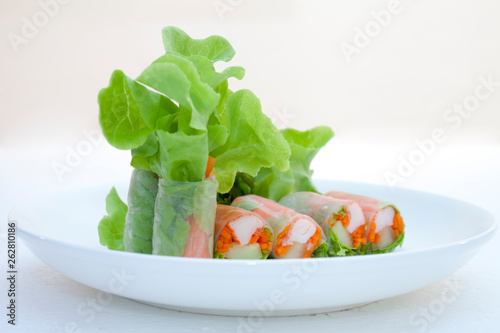Salad roll on a wood dish in white background