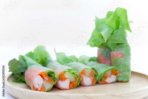 Salad roll on a wood dish in white background
