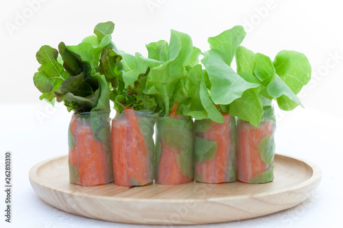 Salad roll on a wood dish in white background