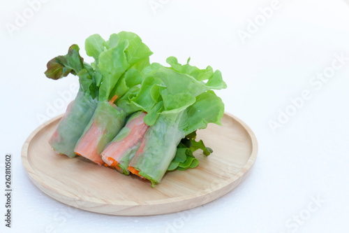 Salad roll on a wood dish in white background