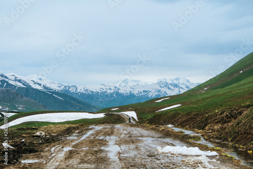 Mud Dirt Road in the Caucasus mountains and snow