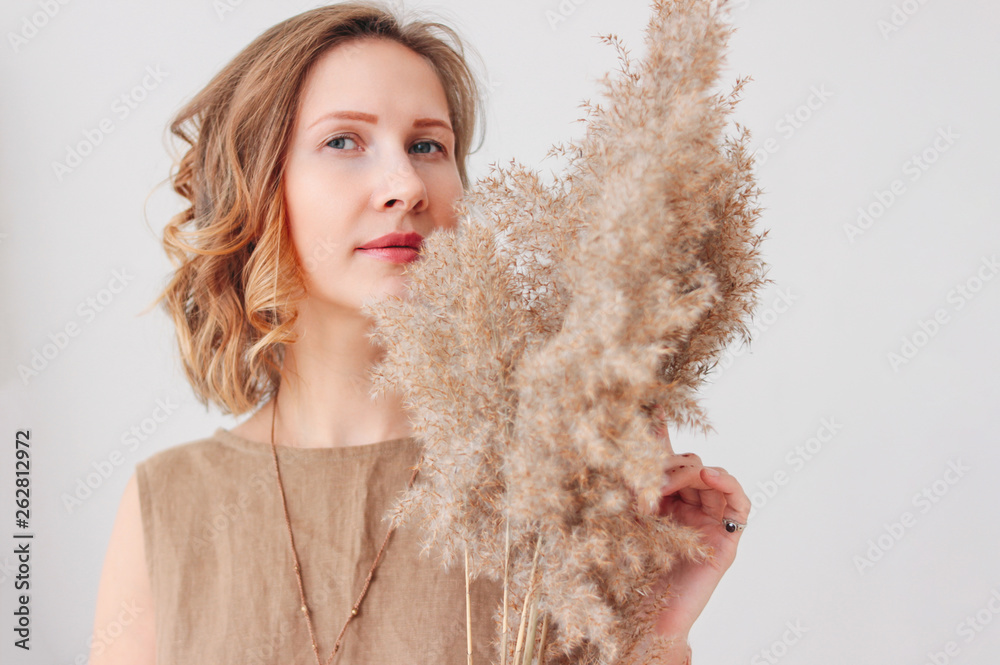 Close up portrait of beautiful young woman in linen dress with dried flowers, eco natural beauty concept Close up portrait of beautiful young woman in linen dress with dried flowers, eco natural beauty concept