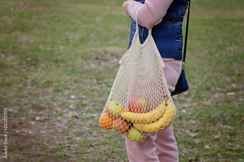 Young Woman Holding Reusable String Shopping Grocery Eco Bag with fruits